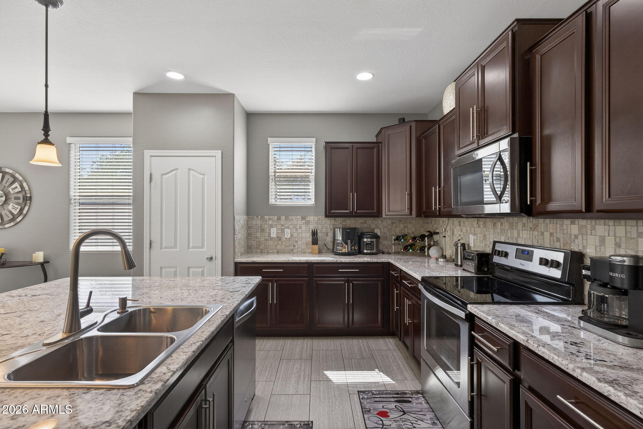 921 South Swallow Lane Gilbert, AZ 85296 - Photo 10 of 36 a kitchen with granite countertop a sink stove and cabinets
