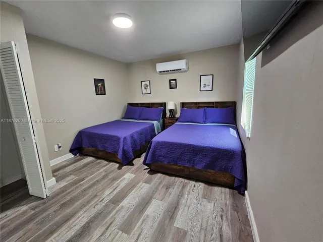 a bedroom with two beds and a dresser