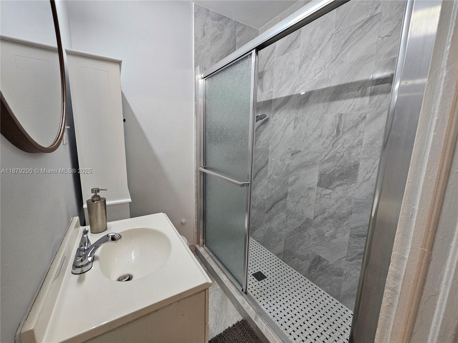 1265 Southwest 4th Street, Unit 4 Miami, FL 33130 - Photo 22 of 24 a bathroom with a sink a toilet and a mirror