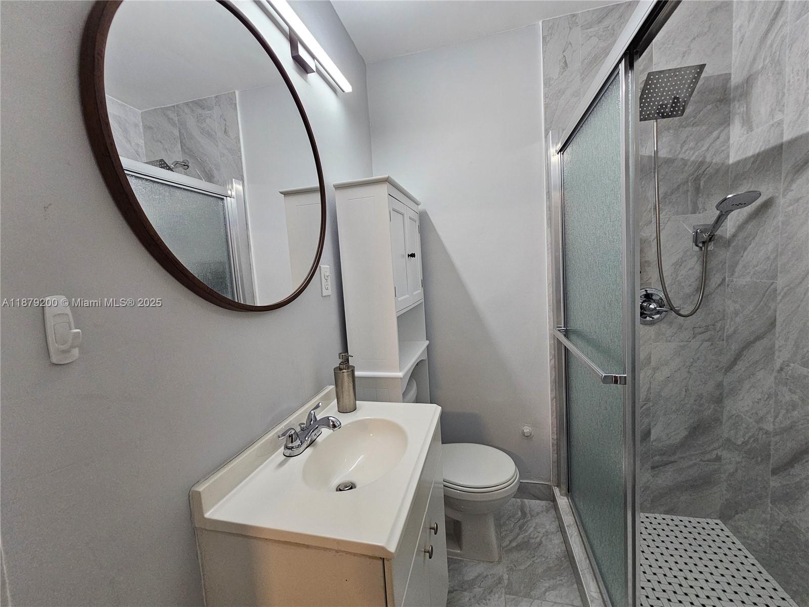 1265 Southwest 4th Street, Unit 4 Miami, FL 33130 - Photo 23 of 24 a bathroom with a sink a toilet and a mirror