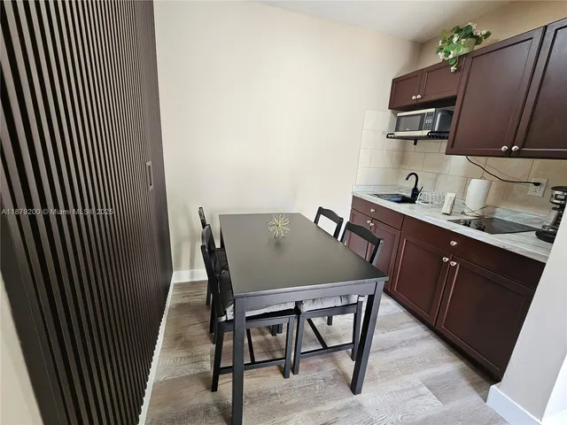 a kitchen with a sink chairs and microwave