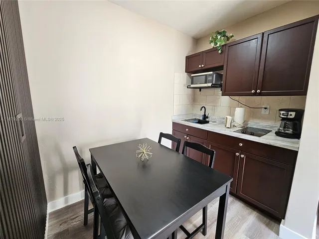 a kitchen with a table chairs and a refrigerator