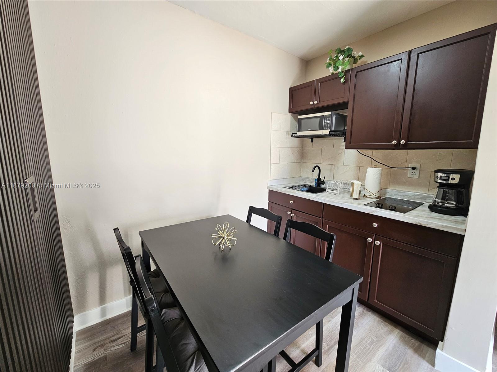1265 Southwest 4th Street, Unit 4 Miami, FL 33130 - Photo 8 of 24 a kitchen with a table chairs and a refrigerator