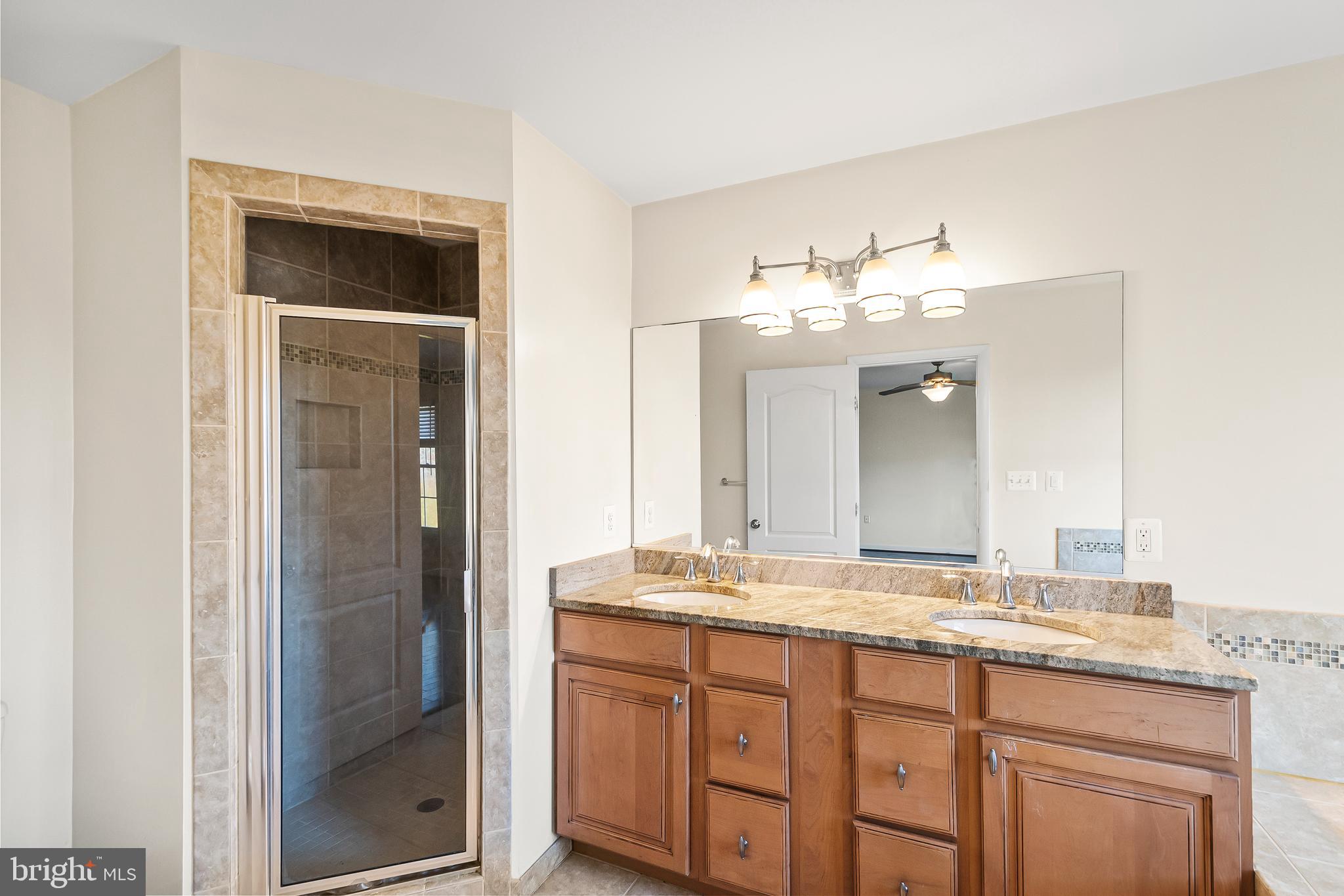 7872 Azalea Cove Terrace Alexandria, VA 22315 - Photo 19 of 30 a bathroom with a granite countertop sink and a mirror