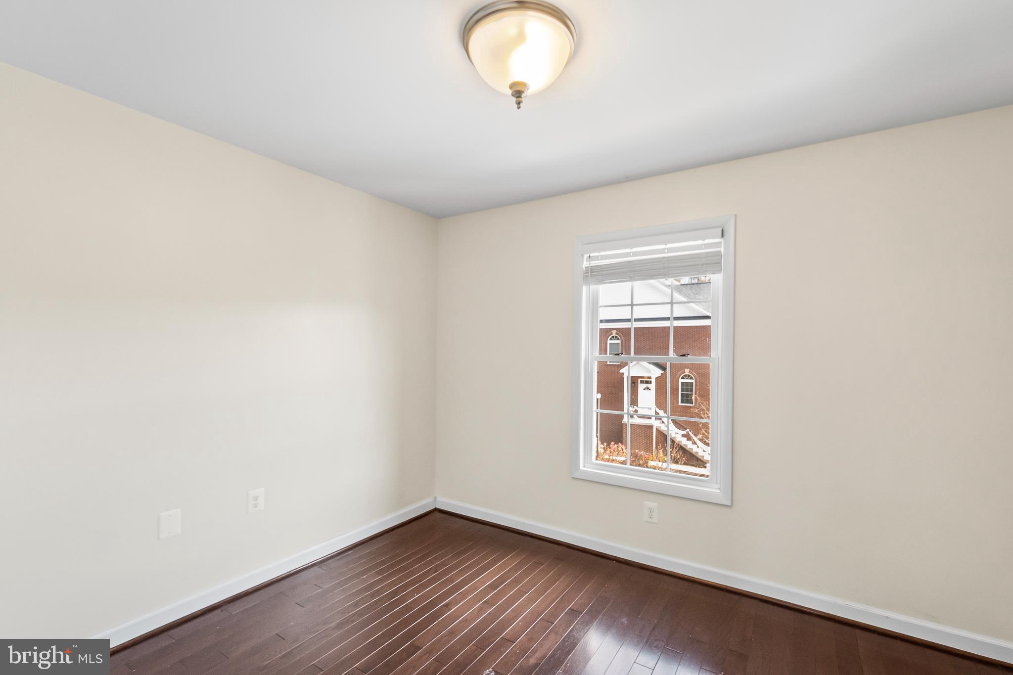 7872 Azalea Cove Terrace Alexandria, VA 22315 - Photo 24 of 30 a view of an empty room with wooden floor and a window