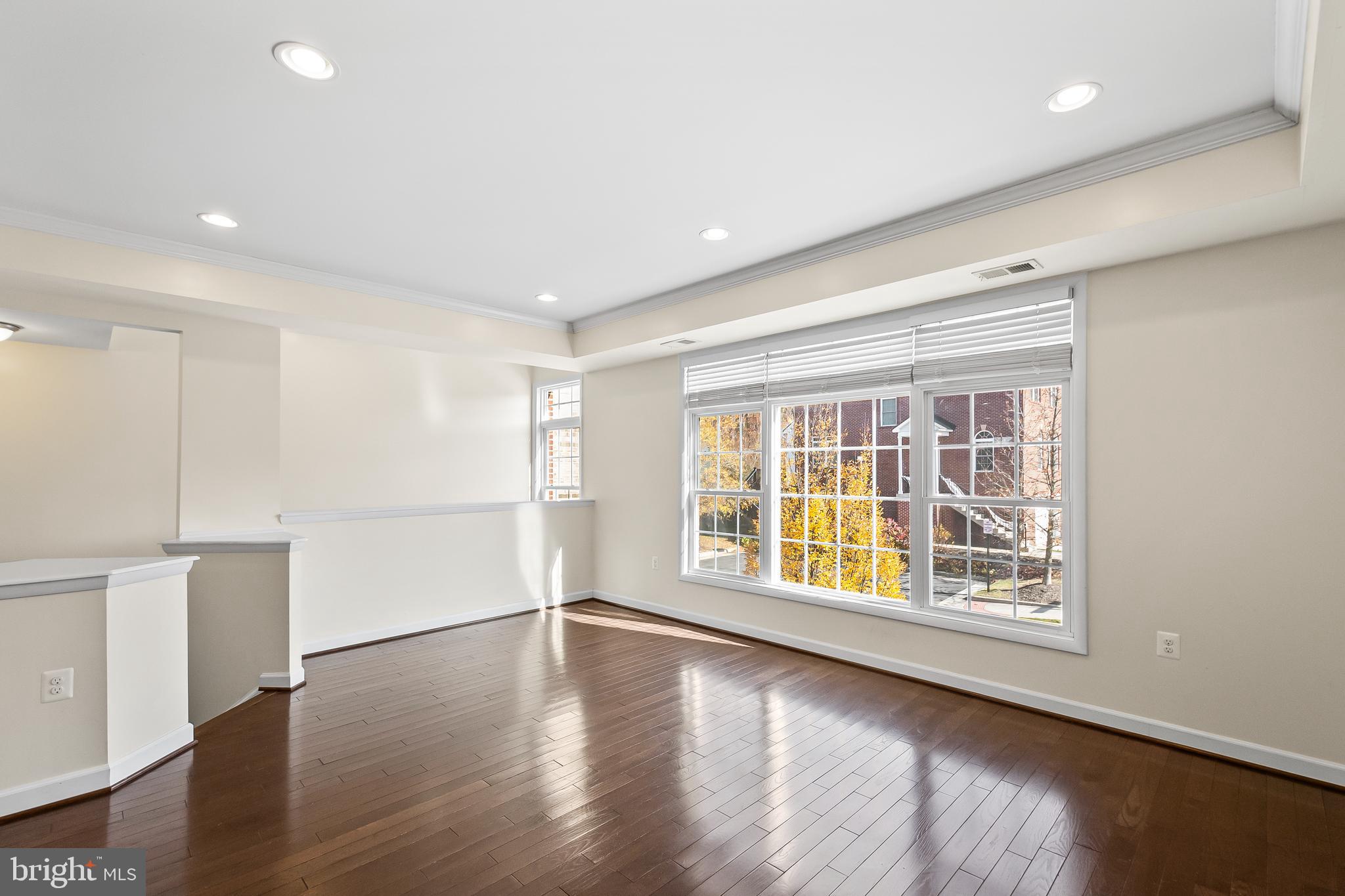 7872 Azalea Cove Terrace Alexandria, VA 22315 - Photo 7 of 30 a view of an empty room with wooden floor and a window