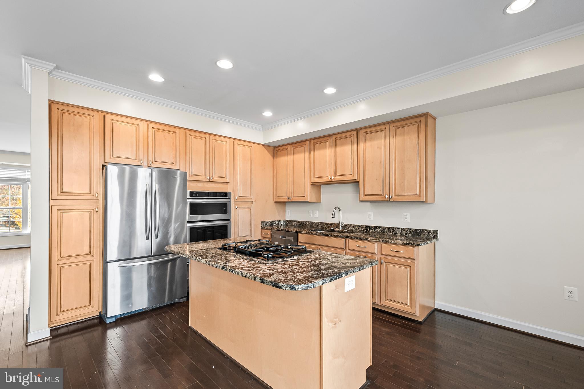 7872 Azalea Cove Terrace Alexandria, VA 22315 - Photo 10 of 30 a kitchen with a refrigerator stove and wooden cabinets