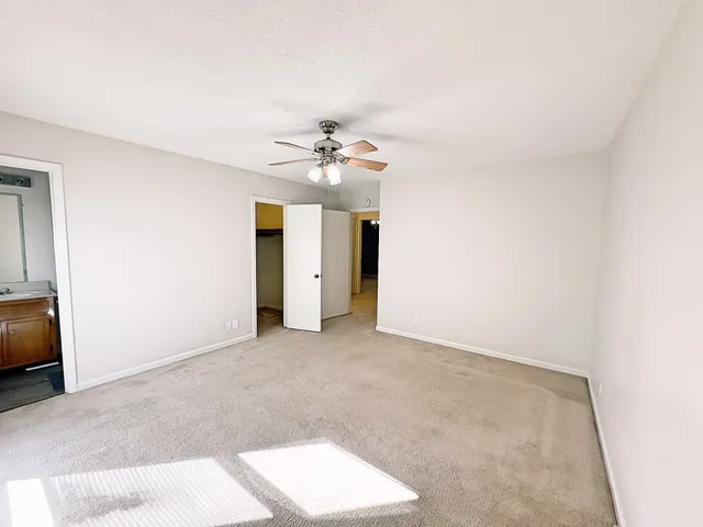 an empty room with a ceiling fan and a window