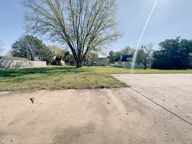 a view of a yard with large trees