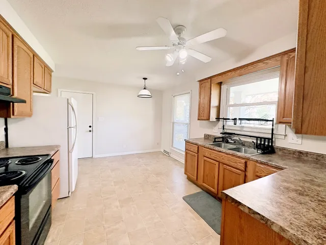 a kitchen with stainless steel appliances granite countertop a stove a sink and a refrigerator