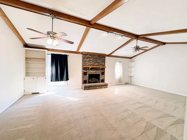 a view of an empty room with a fireplace and a window