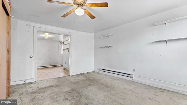 an empty room with closet and a chandelier fan