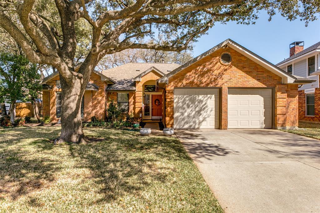 a front view of a house with a large tree