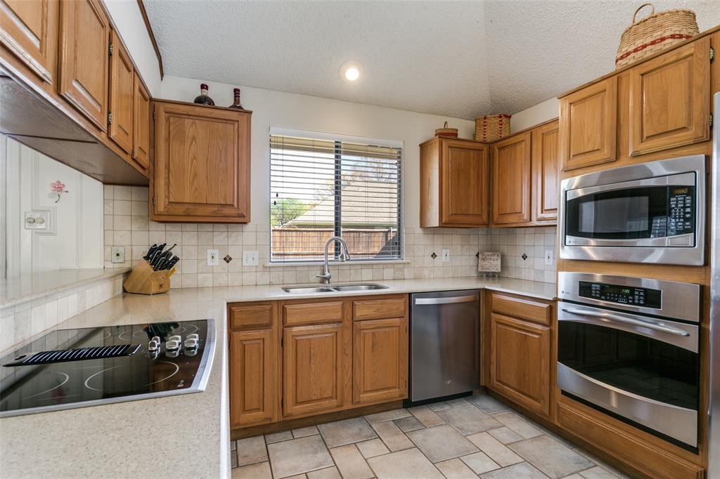 3414 Spring Willow Drive Grapevine, TX 76051 - Photo 13 of 25 a kitchen with a sink a stove and cabinets