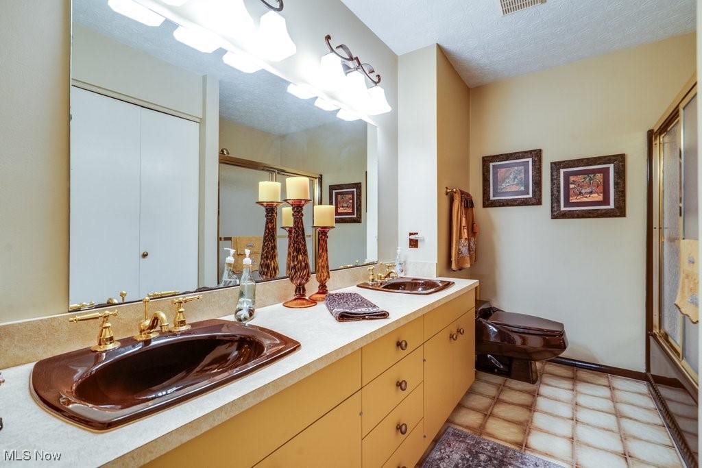 3404 South Smith Road Fairlawn, OH 44333 - Photo 19 of 37 Second floor hallway Bathroom featuring double vanity, a shower stall, and a textured ceiling. This bathroom services the 2nd and 3rd bedrooms.
