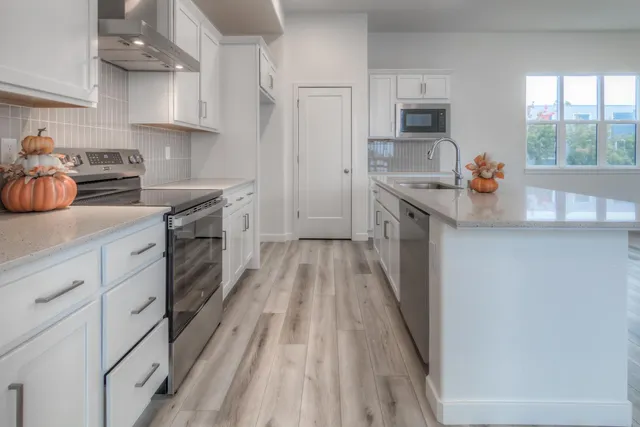 a kitchen with granite countertop a sink stove and cabinets