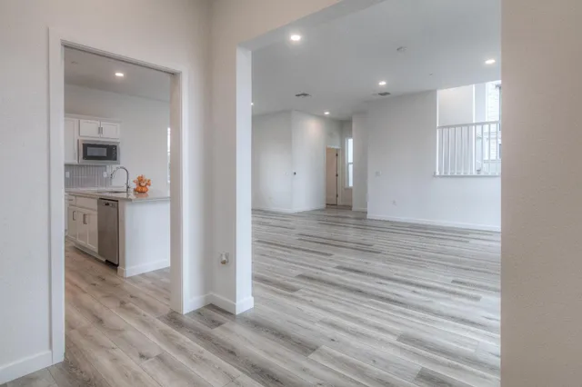 an empty room with wooden floor and a bathroom