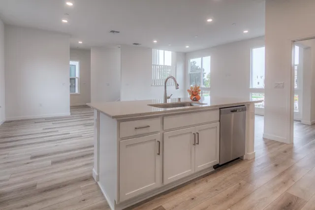 a kitchen with white cabinets appliances and sink