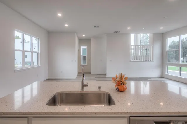 a kitchen with kitchen island a sink appliances and a window