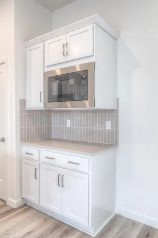 a kitchen with white cabinets and white appliances