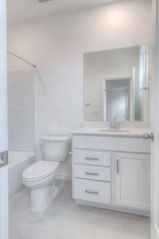 a bathroom with a toilet a sink and a mirror