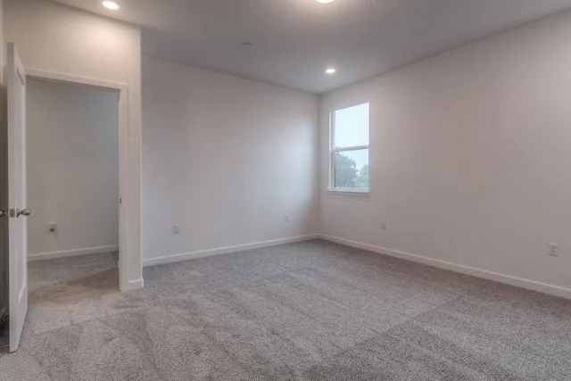 an empty room with windows and closet
