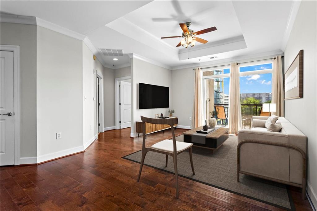 325 East Paces Ferry Road Northeast, Unit 703 Atlanta, GA 30305 - Photo 11 of 31 a living room with furniture and a flat screen tv with wooden floor