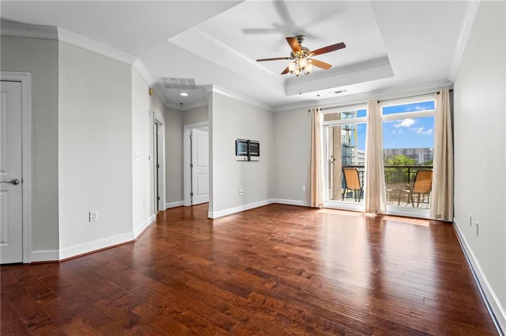 325 East Paces Ferry Road Northeast, Unit 703 Atlanta, GA 30305 - Photo 12 of 31 an empty room with wooden floor and ceiling fan