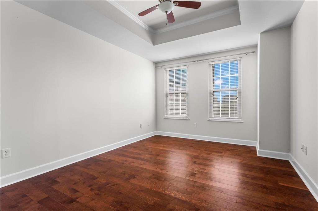 325 East Paces Ferry Road Northeast, Unit 703 Atlanta, GA 30305 - Photo 17 of 31 an empty room with wooden floor and windows