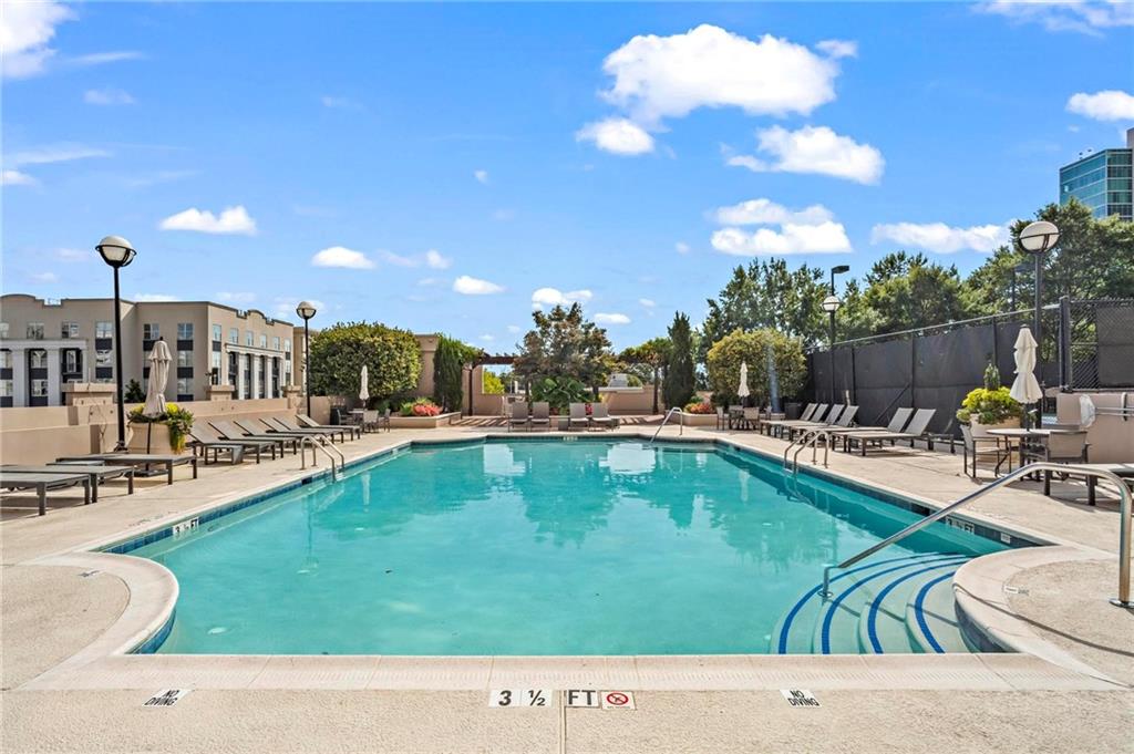 325 East Paces Ferry Road Northeast, Unit 703 Atlanta, GA 30305 - Photo 26 of 31 a swimming pool with outdoor seating and yard