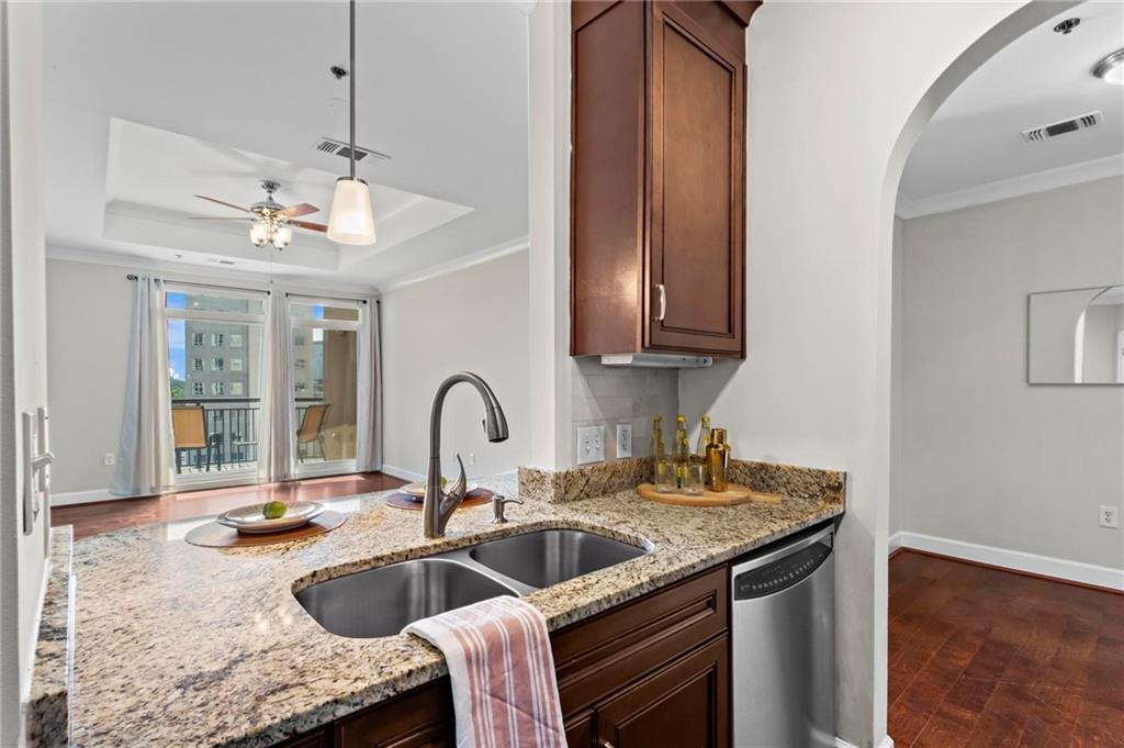325 East Paces Ferry Road Northeast, Unit 703 Atlanta, GA 30305 - Photo 6 of 31 a kitchen with granite countertop a sink stainless steel appliances and cabinets
