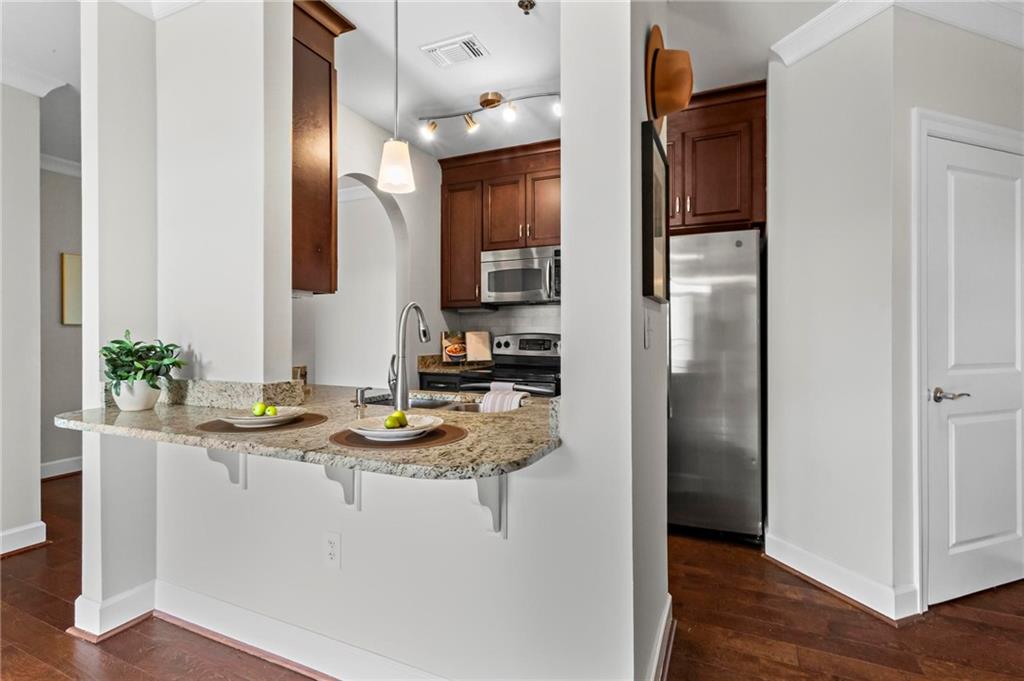 325 East Paces Ferry Road Northeast, Unit 703 Atlanta, GA 30305 - Photo 8 of 31 a kitchen with stainless steel appliances granite countertop a refrigerator and a sink