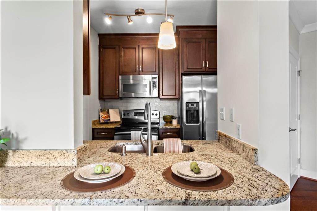 325 East Paces Ferry Road Northeast, Unit 703 Atlanta, GA 30305 - Photo 9 of 31 a kitchen with stainless steel appliances granite countertop a sink and cabinets