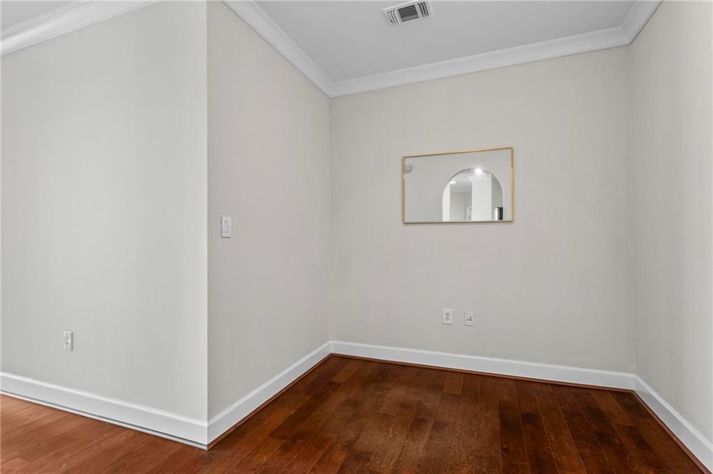325 East Paces Ferry Road Northeast, Unit 703 Atlanta, GA 30305 - Photo 10 of 31 a view of an empty room with wooden floor