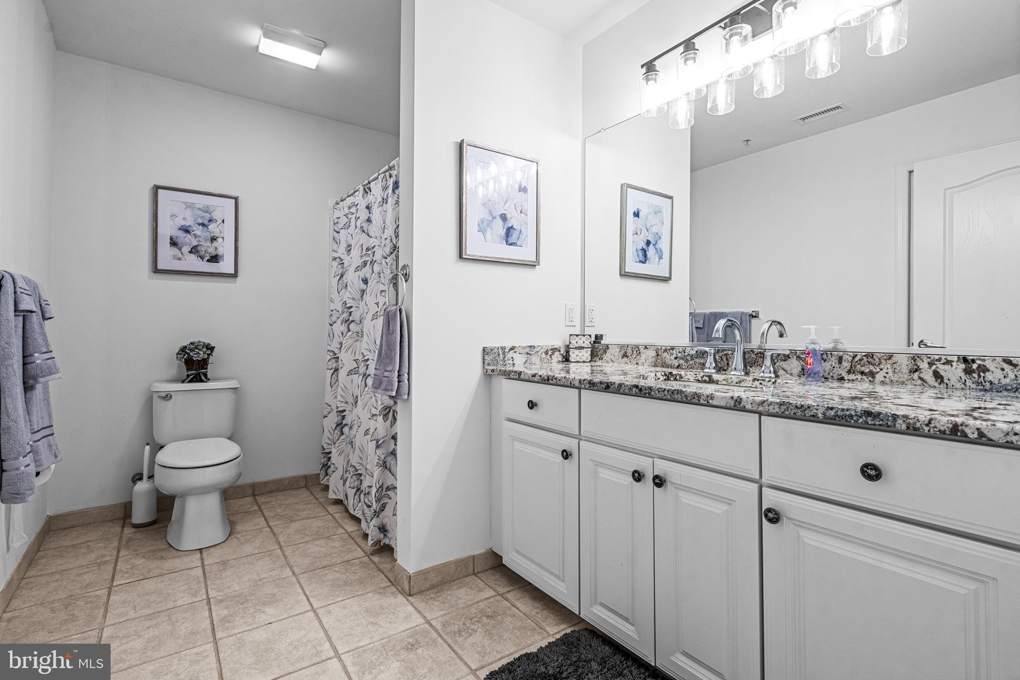 301 East Rochester Avenue, Unit 409 Wildwood, NJ 08260 - Photo 18 of 31 a bathroom with a granite countertop sink a toilet and a mirror