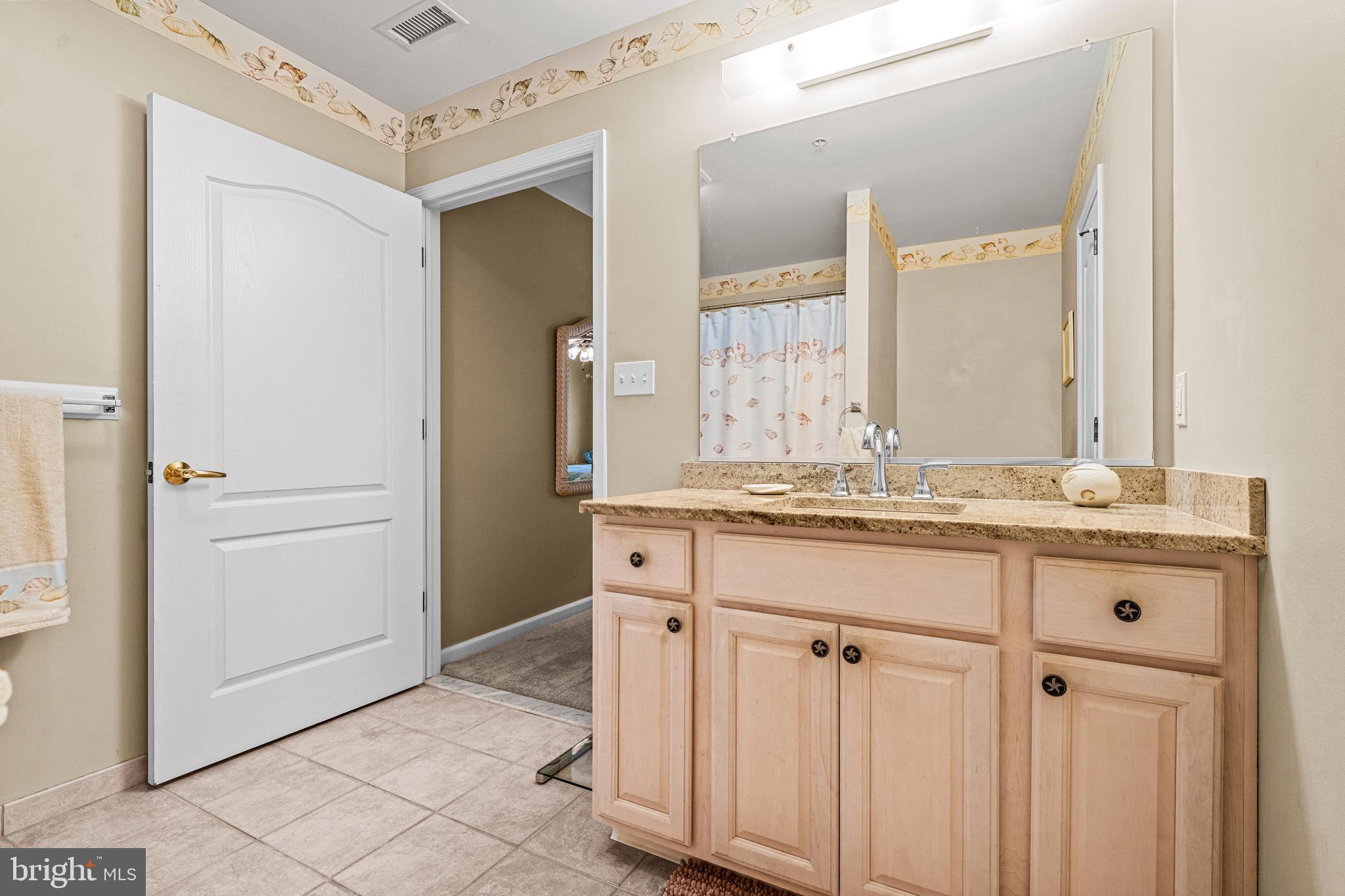 301 East Rochester Avenue, Unit 409 Wildwood, NJ 08260 - Photo 23 of 31 a bathroom with a granite countertop sink and a mirror