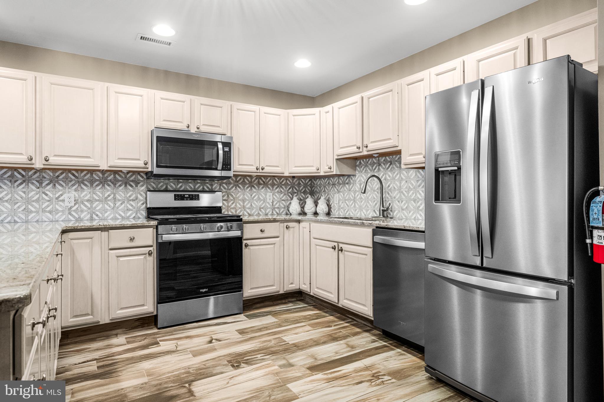 301 East Rochester Avenue, Unit 409 Wildwood, NJ 08260 - Photo 5 of 31 a kitchen with stainless steel appliances granite countertop a refrigerator stove a sink and microwave