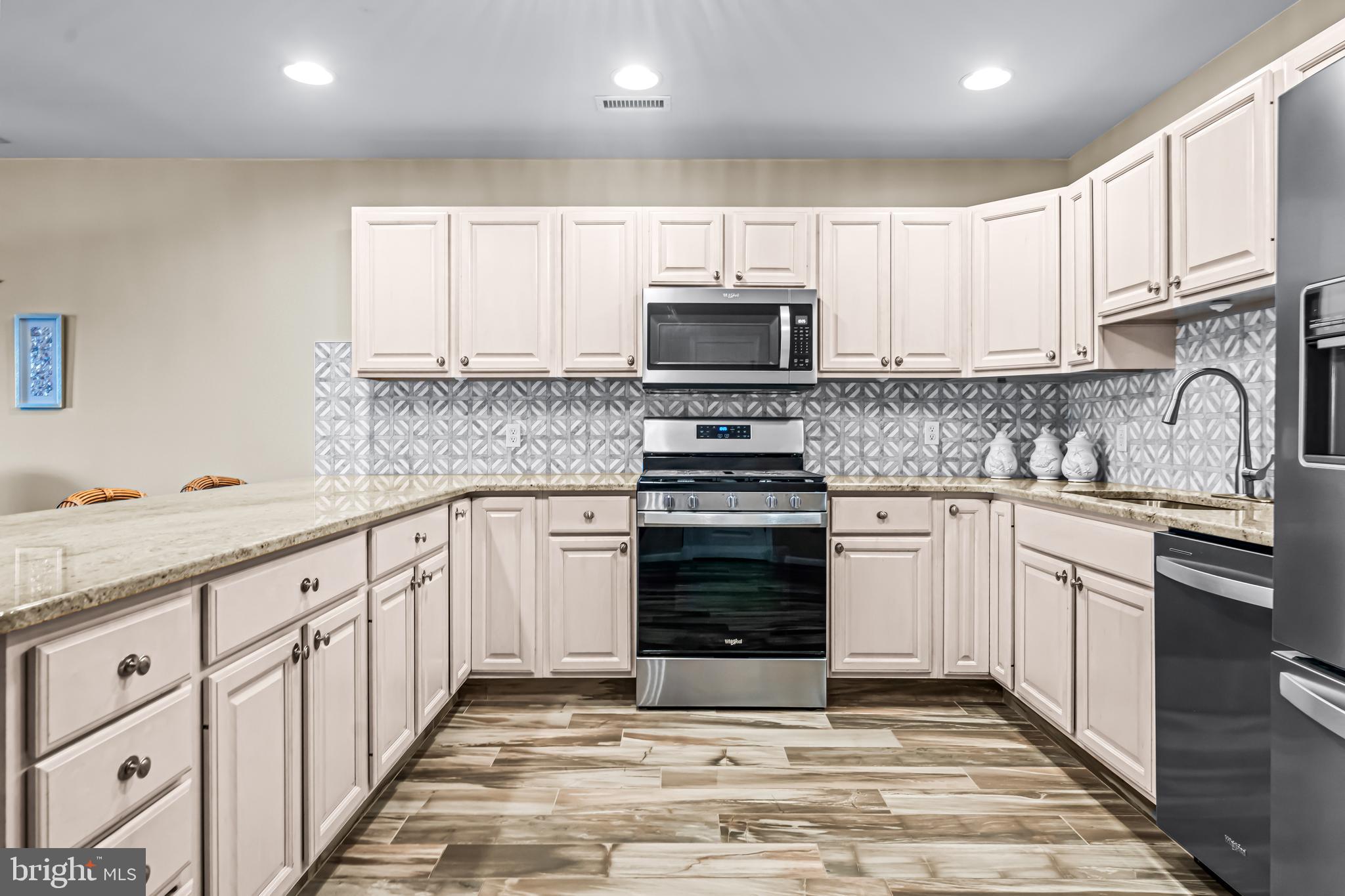 301 East Rochester Avenue, Unit 409 Wildwood, NJ 08260 - Photo 6 of 31 a kitchen with granite countertop a sink a stove top oven and cabinets