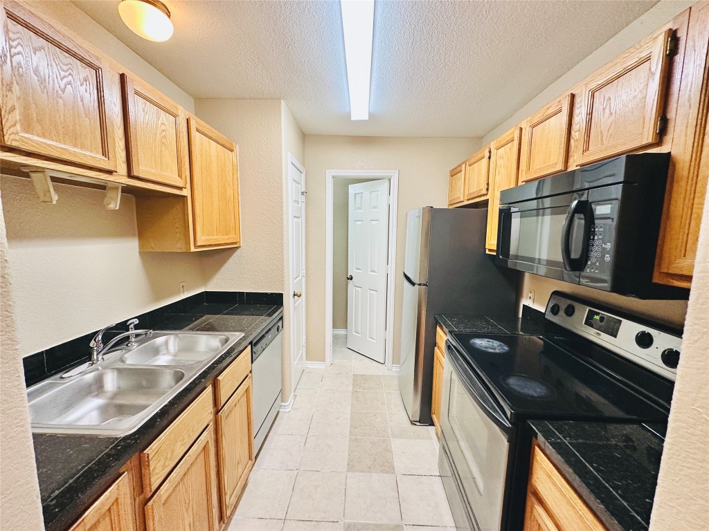 8814 Schick Road, Unit D Austin, TX 78729 - Photo 11 of 26 a kitchen that has a sink and a stove