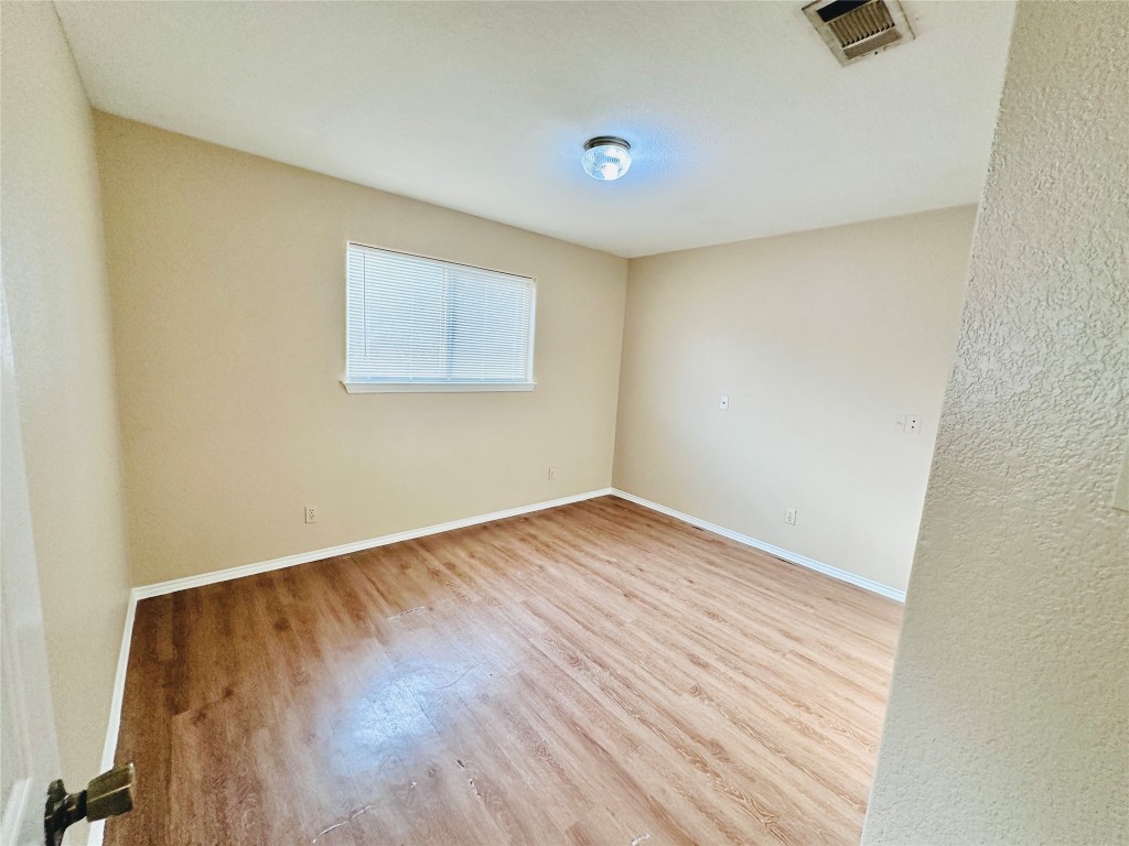 8814 Schick Road, Unit D Austin, TX 78729 - Photo 16 of 26 an empty room with wooden floor and windows