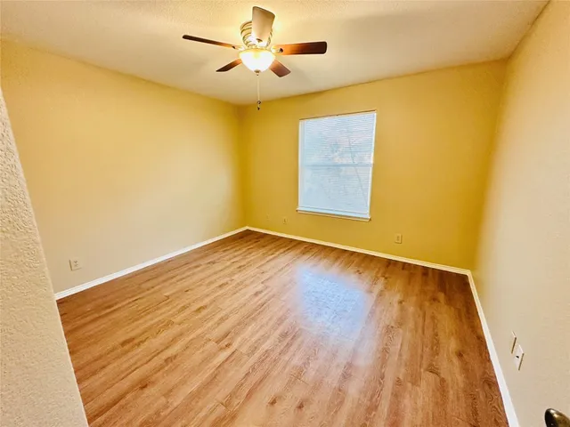 a view of a hallway with wooden floor and cabinet