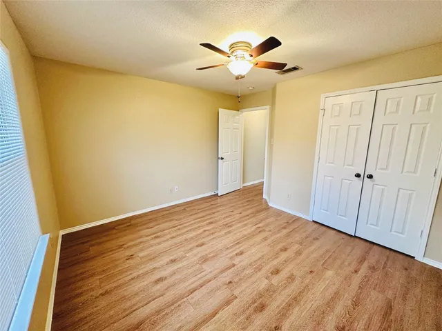 a view of room with wooden floor and ceiling fan