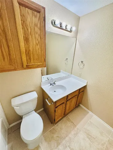 a bathroom with a tub sink mirror and toilet