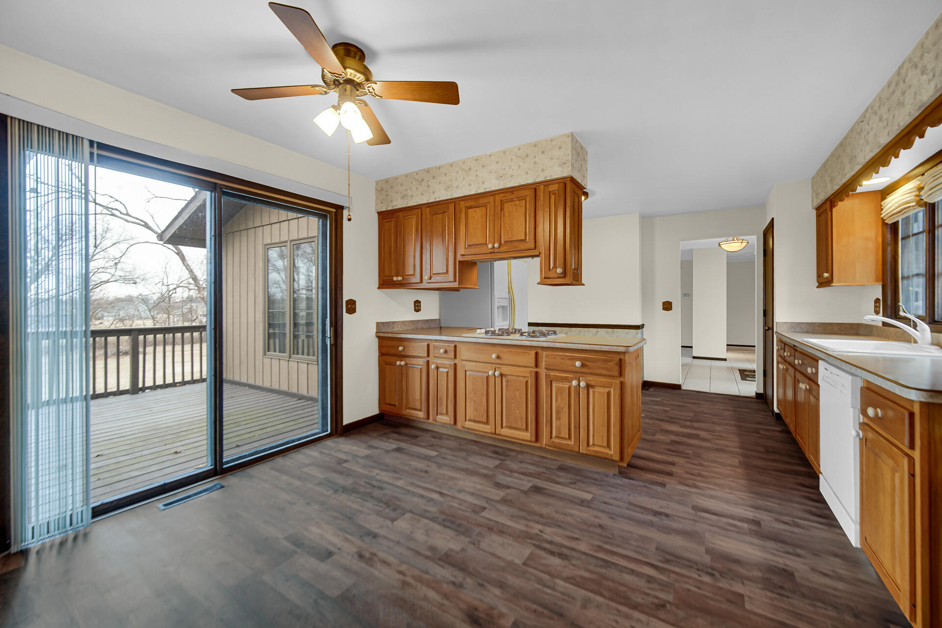 6955 Briergate Court Demotte, IN 46310 - Photo 15 of 44 a kitchen with stainless steel appliances granite countertop a stove a sink dishwasher a refrigerator and a dining table with wooden floor