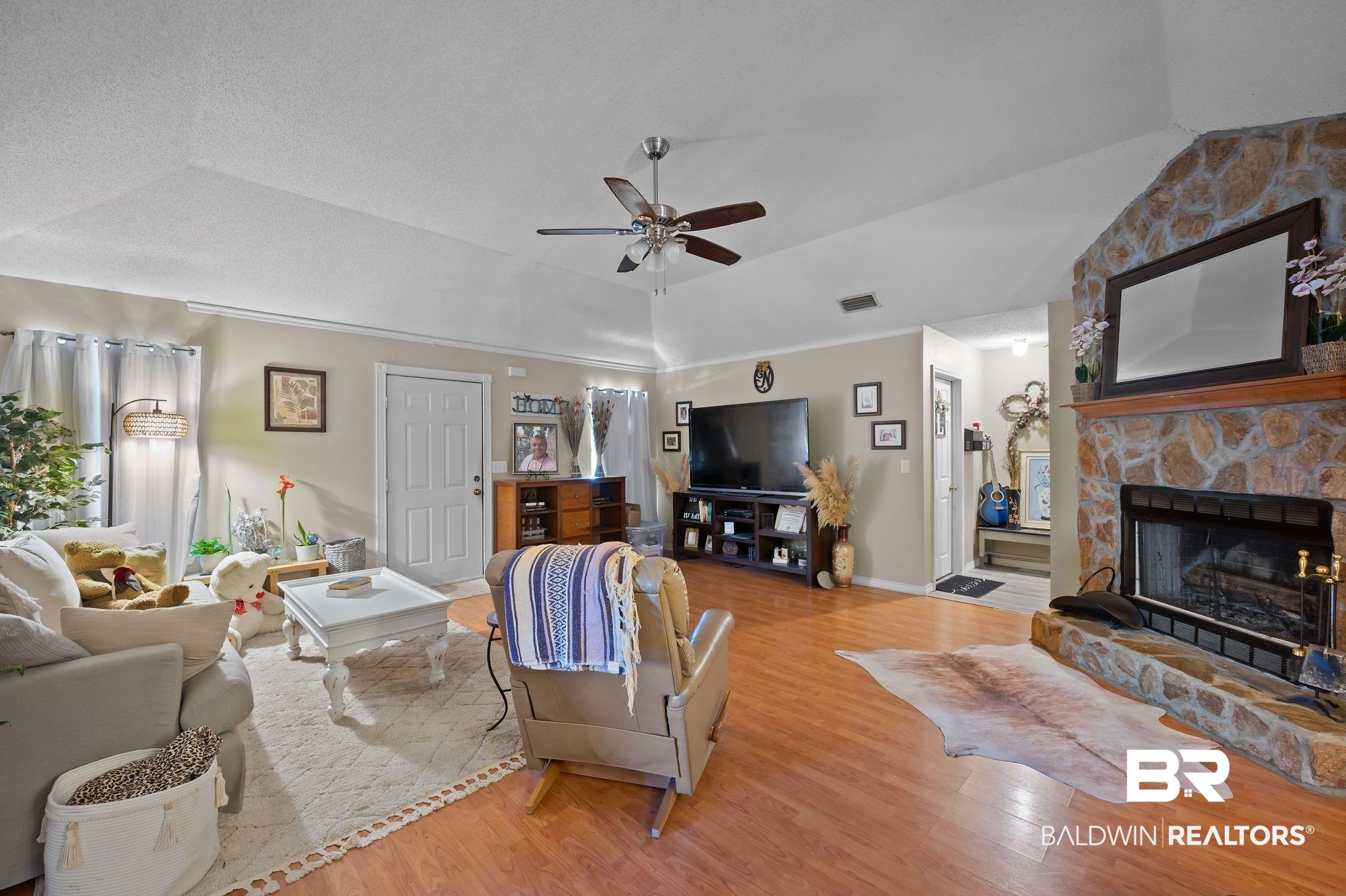 52923 Ammons Road Perdido, AL 36562 - Photo 9 of 35 Living room with wood finished floors, ceiling fan, a fireplace, lofted ceiling, and a tray ceiling
