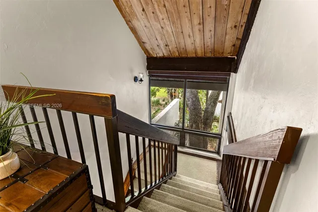 a bedroom with a bed and a flat tv screen on the dresser
