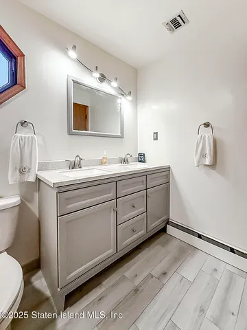 a bathroom with a toilet sink and mirror