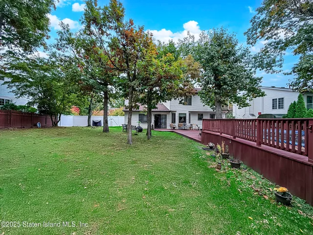 a view of house with backyard and a garden