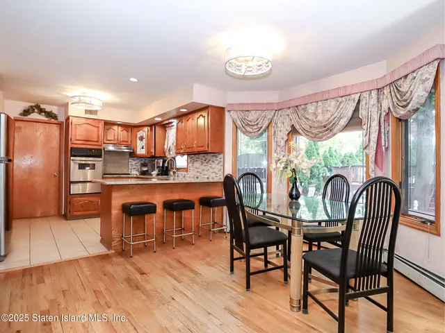 a kitchen with stainless steel appliances granite countertop a table chairs and a refrigerator