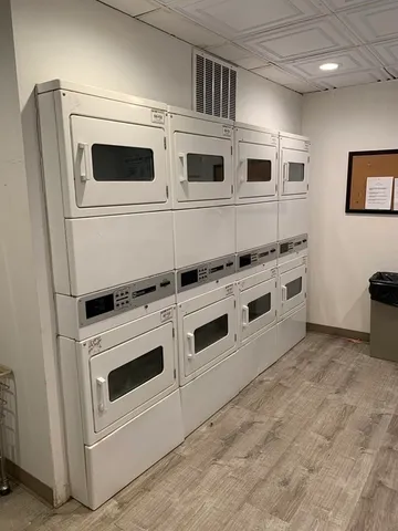 a view of kitchen with stainless steel appliances wooden cabinet and a stove top oven